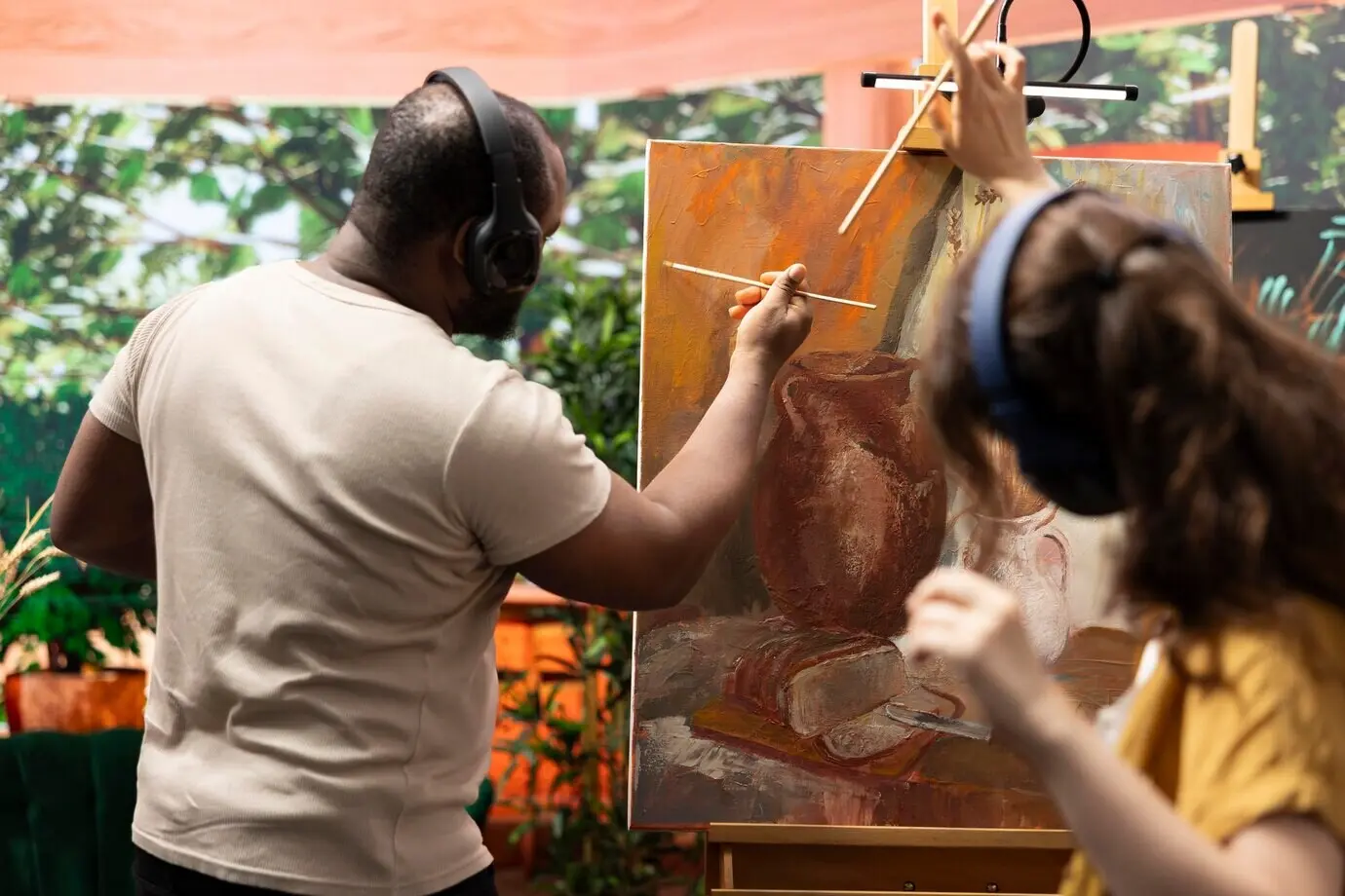Ein Team von Künstlern malt eine schöne rustikale Kreation auf einer Leinwand.