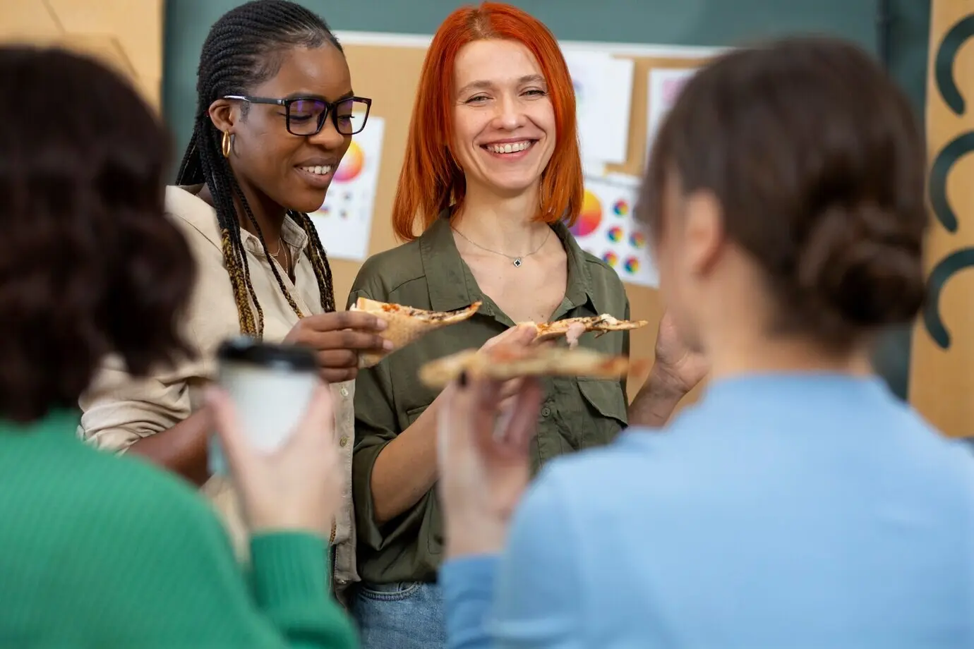 Mitarbeitende essen köstliche Pizza bei der Arbeit.